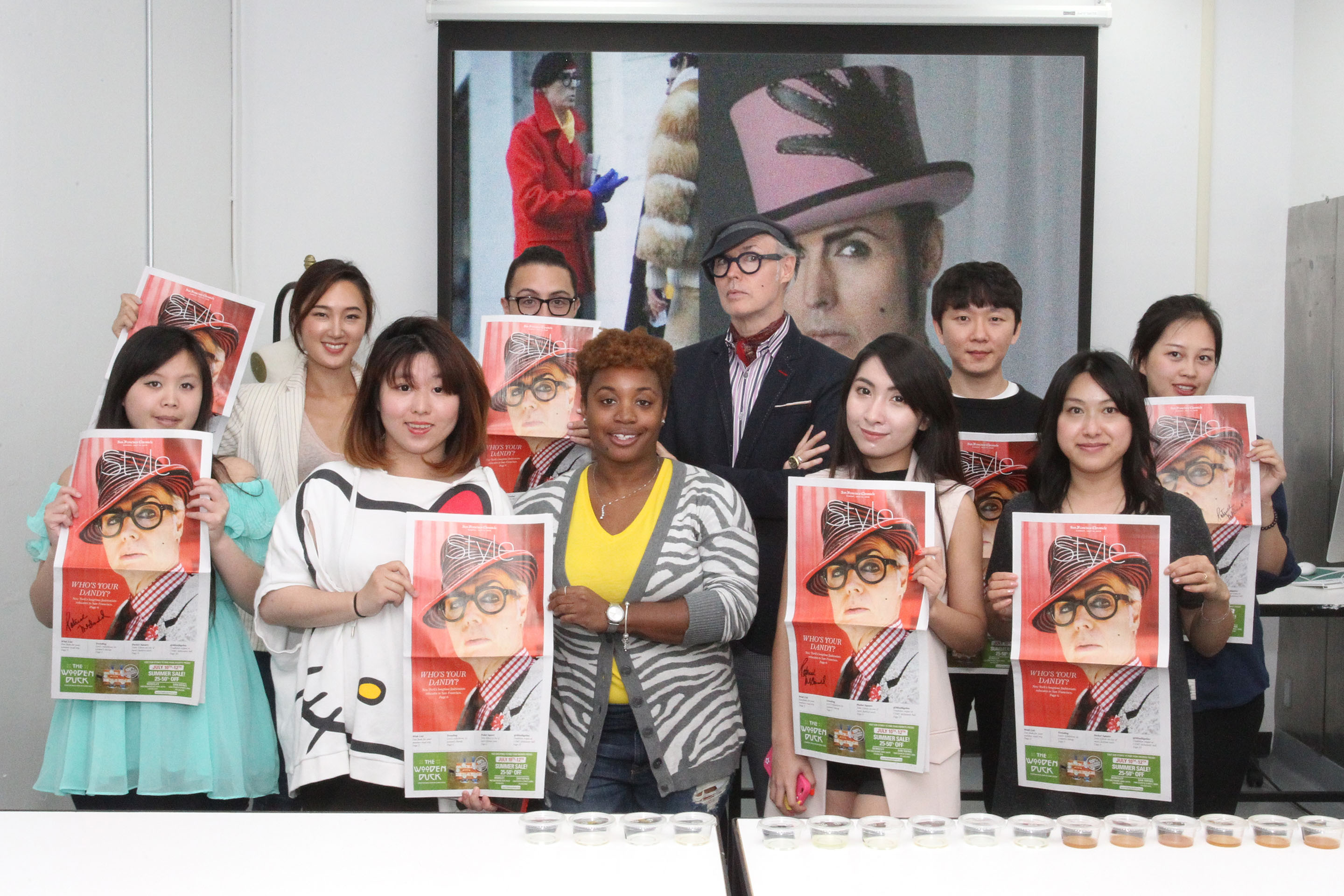 Dandy Patrick McDonald with fashion merchandising students pose with his San Francisco Chronicle Style Section cover. Photo by Bob Toy.