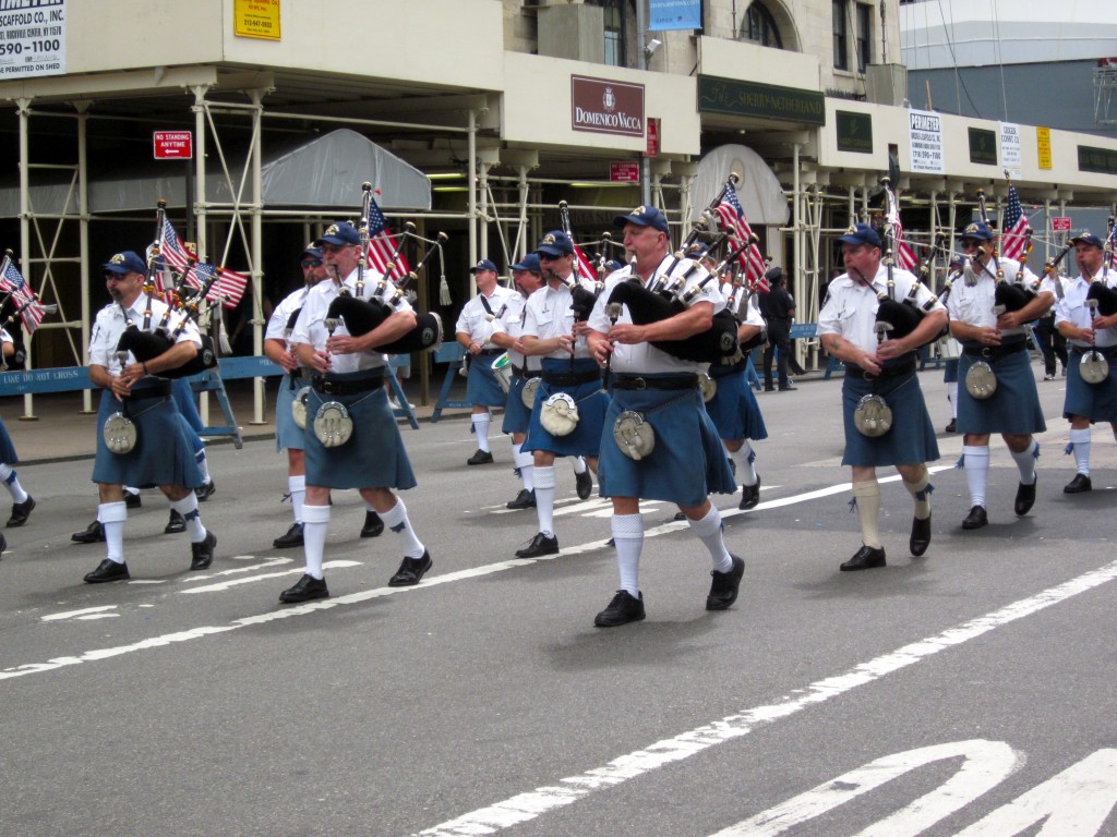 Sword and Light Pipe Band in kilts with flags