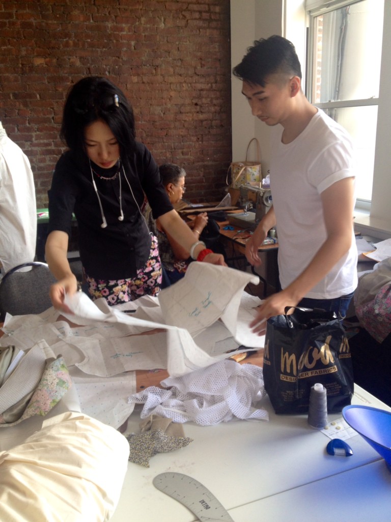 Menswear collection collaborators Jingci Wang and Max Lu, both MFA Fashion Design, consult patterns.