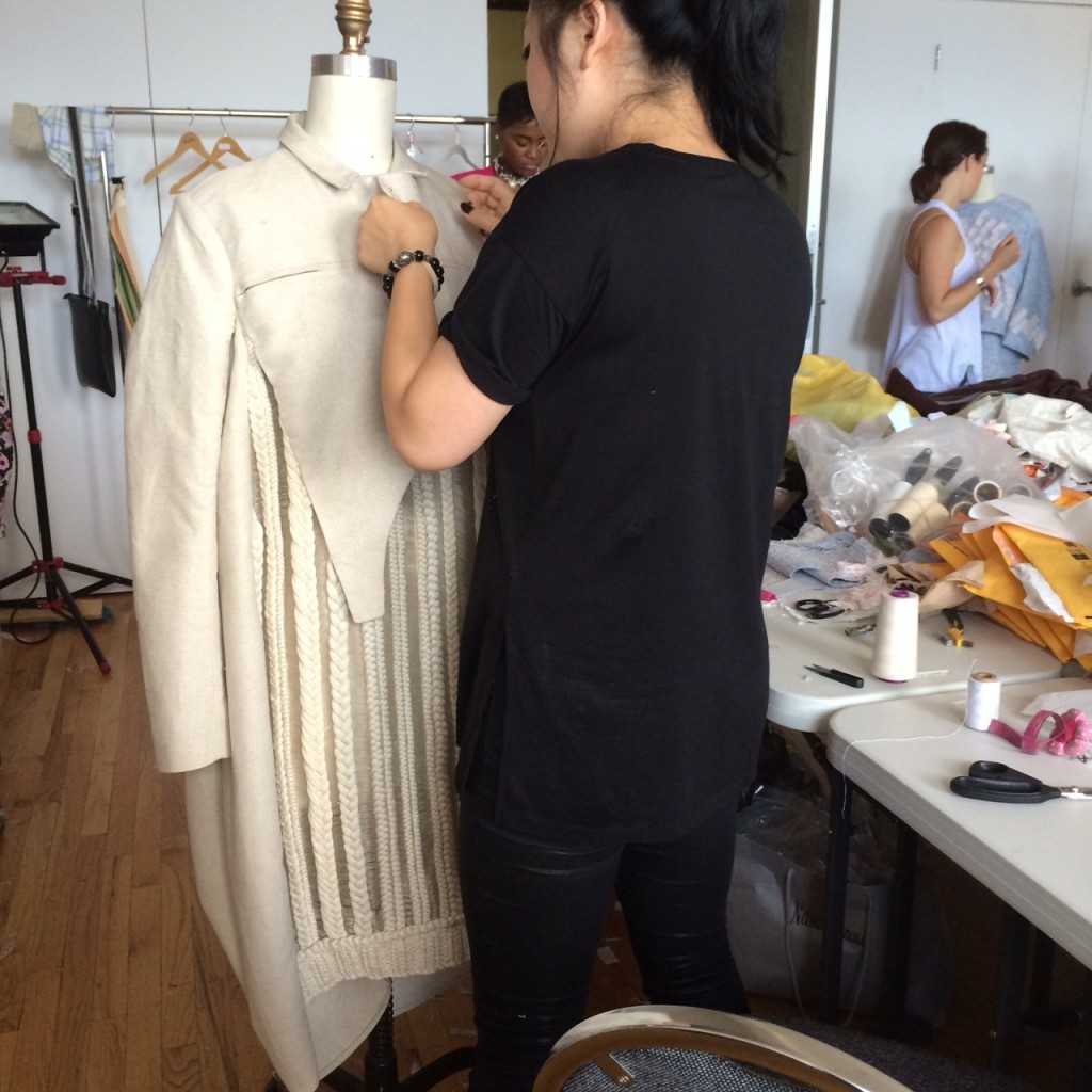 Mia Jianxia Ji, MFA Fashion and Knitwear Design, puts finishing touches on a coat.