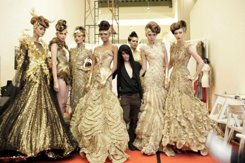 Tex Saverion surrounded by models in his designs